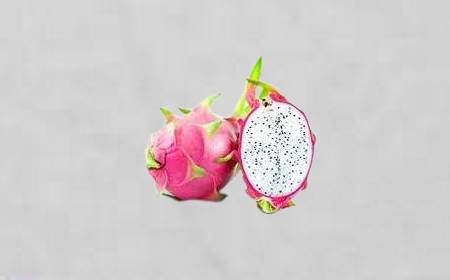 Pitaya rose coupé en deux, montrant la chair blanche parsemée de graines noires